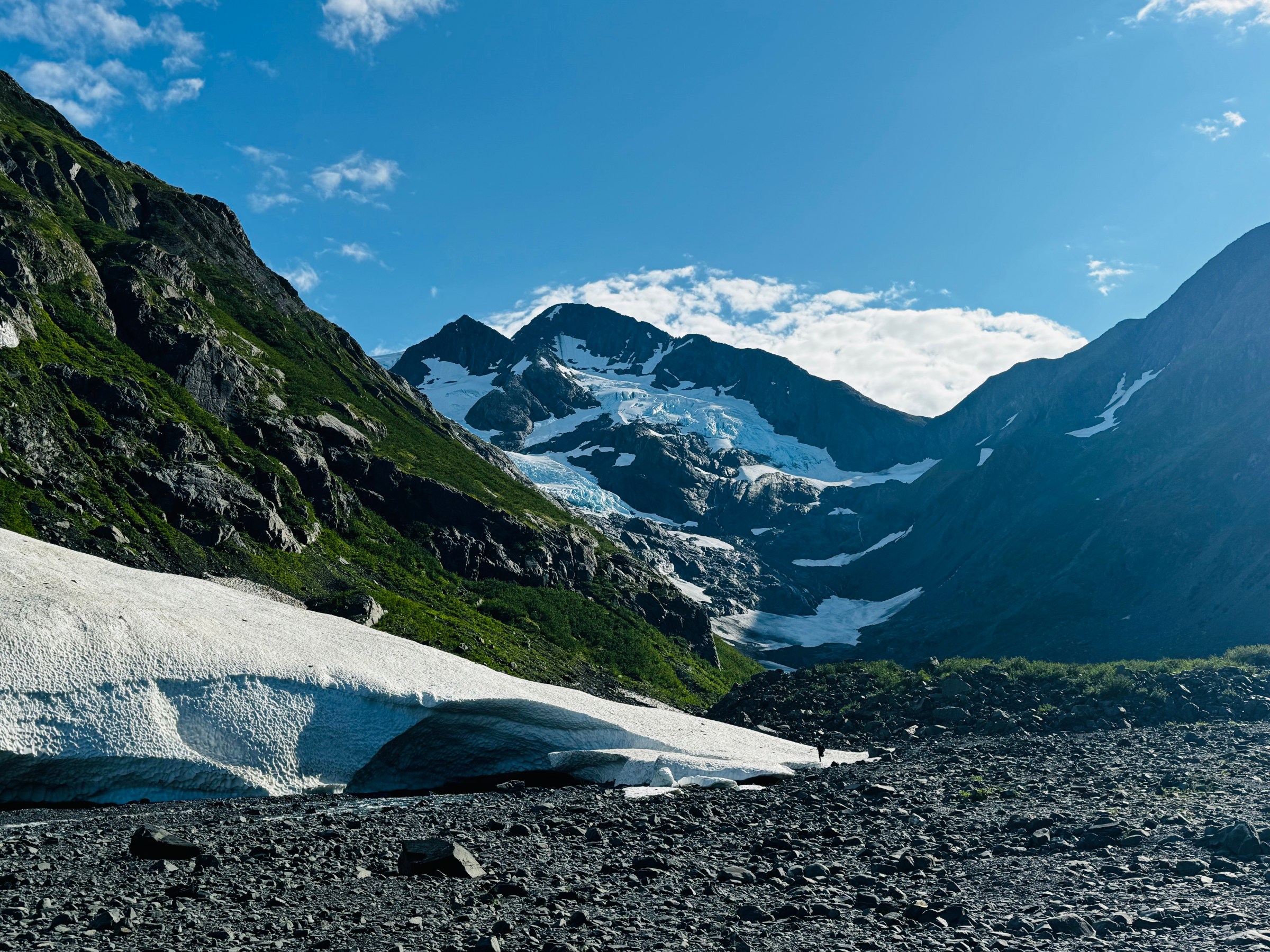 Snowy mountain landscape with glacier under a clear blue sky.